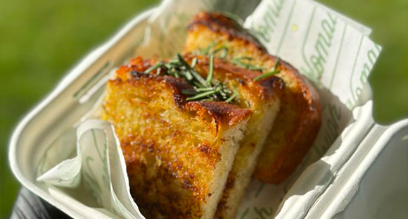 fried bread on a takeaway container blanketed by branded napkins